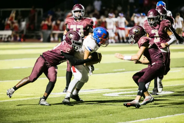 Football player tackling an opponent.