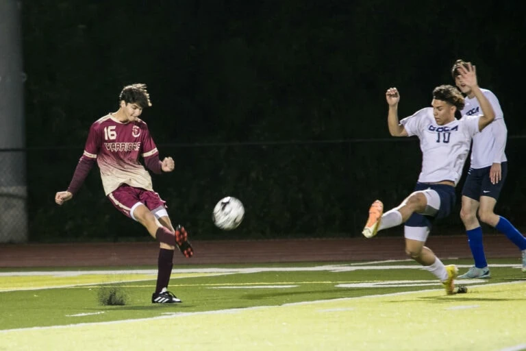 HCS player kicking a soccer ball.